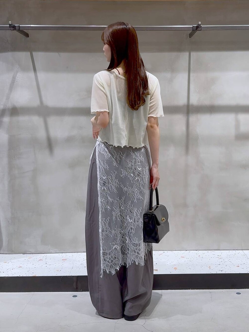 ホワイト系のサンダル、グレー系のその他パンツ、ブラック系のボストンバッグを着用したレディースの夏コーディネートの4枚目の写真