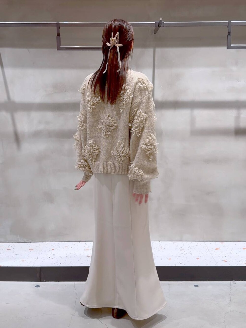 ブラウン系のバレエシューズ、ベージュ系のスカート、ベージュ系のニット/セーターを着用したレディースの冬コーディネートの4枚目の写真