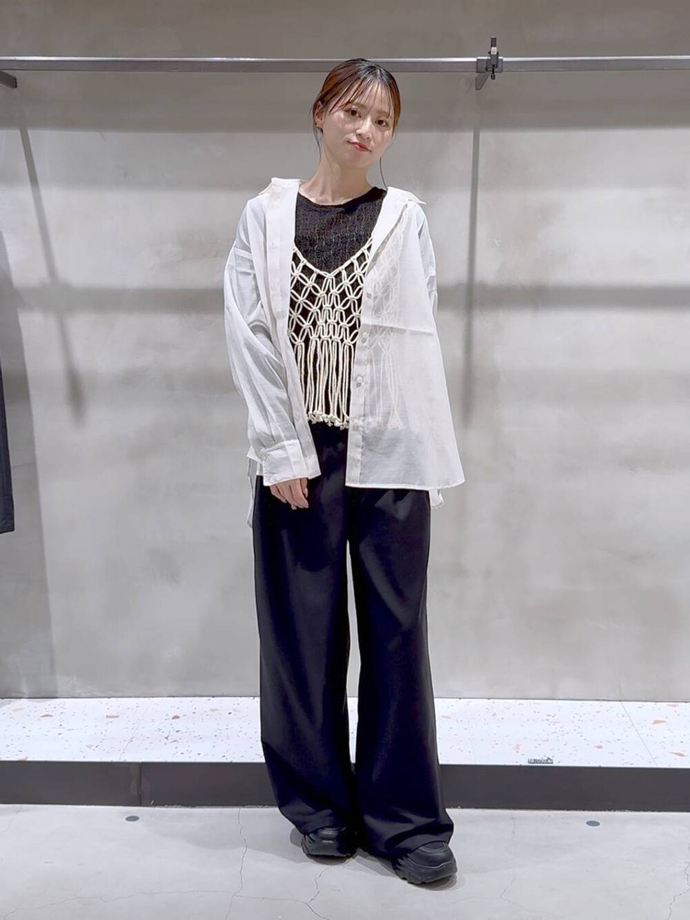 ベージュ系のベスト、ホワイト系のシャツ/ブラウス、ブラック系のスニーカーを着用したレディースの春コーディネートの3枚目の写真