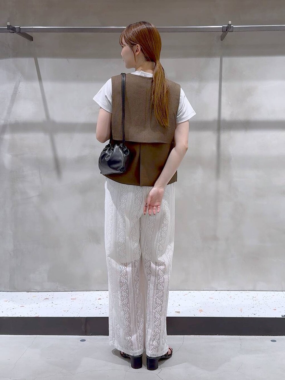 ブラウン系のブルゾン、ホワイト系のその他パンツ、ブラック系のサンダルを着用したレディースの夏コーディネートの6枚目の写真