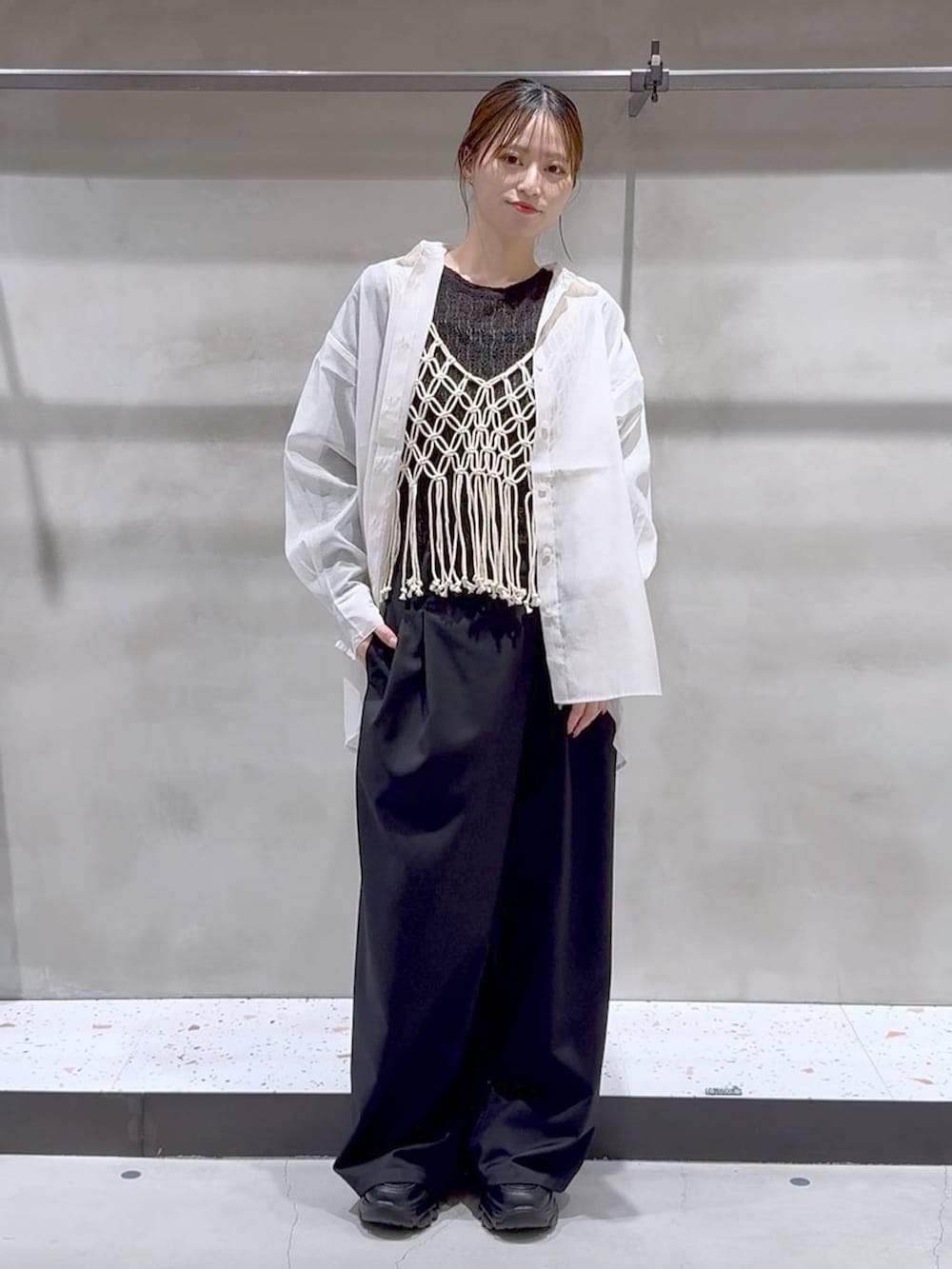 ベージュ系のベスト、ホワイト系のシャツ/ブラウス、ブラック系のスニーカーを着用したレディースの春コーディネートの2枚目の写真