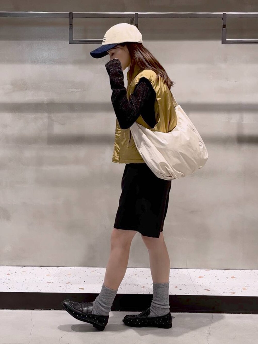 ブラック系のその他パンツ、ベージュ系のダウンベスト、ブラック系のTシャツ/カットソーを着用したレディースの秋コーディネートの4枚目の写真