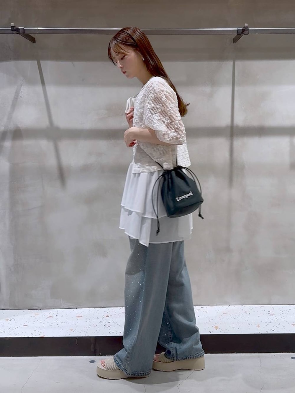 ブルー系のデニムパンツ、ホワイト系のサンダル、ホワイト系のタンクトップを着用したレディースの夏コーディネートの3枚目の写真