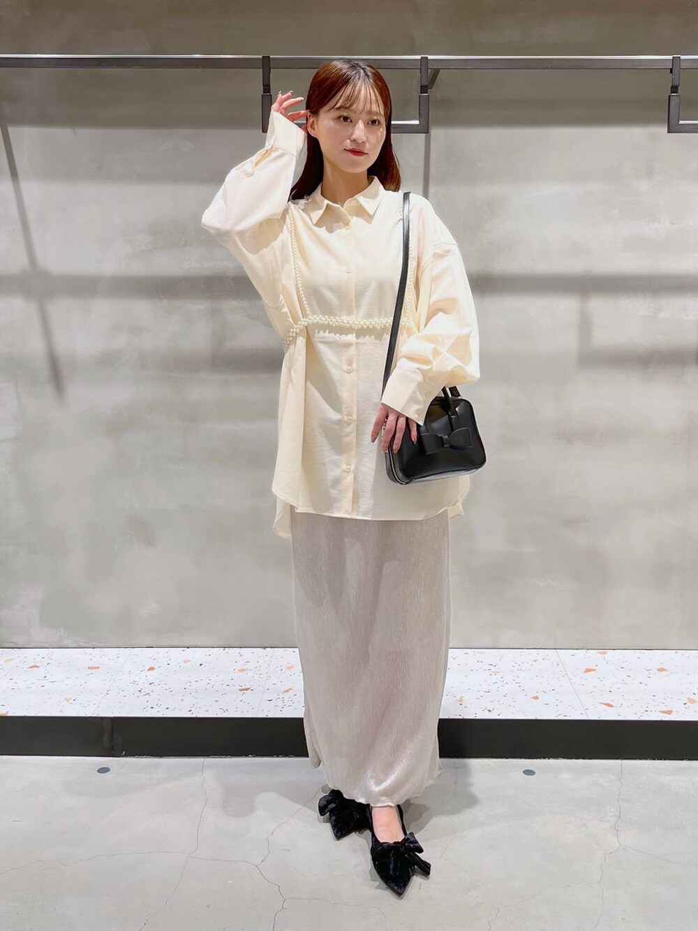 ブラック系のパンプス、ホワイト系のスカート、ブラック系のボストンバッグを着用したレディースの秋コーディネートの2枚目の写真