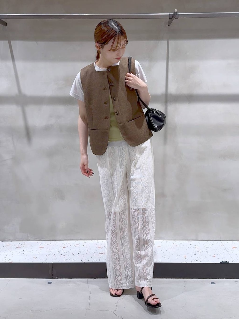 ブラウン系のブルゾン、ホワイト系のその他パンツ、ブラック系のサンダルを着用したレディースの夏コーディネートの3枚目の写真