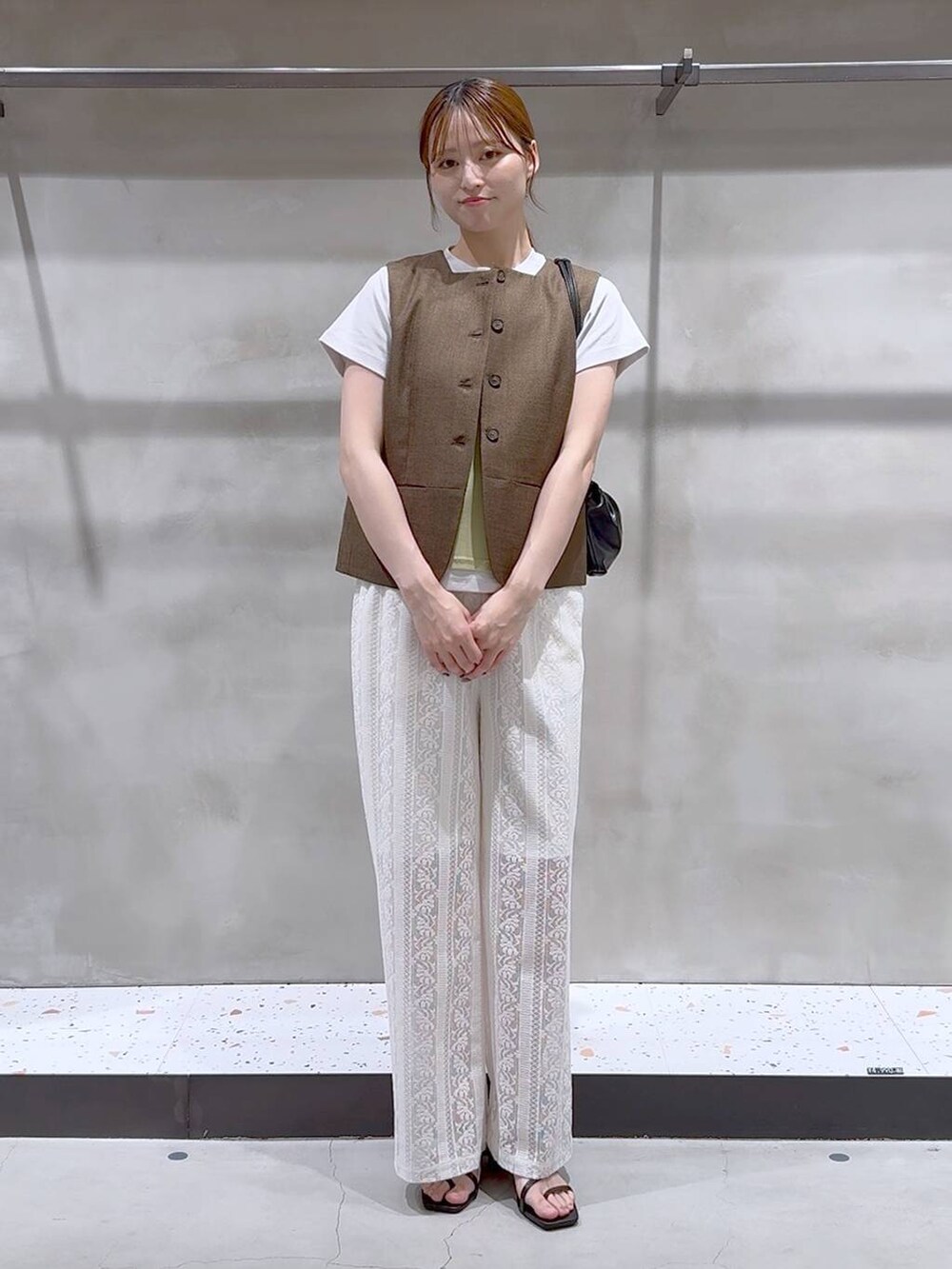 ブラウン系のブルゾン、ホワイト系のその他パンツ、ブラック系のサンダルを着用したレディースの夏コーディネートの2枚目の写真