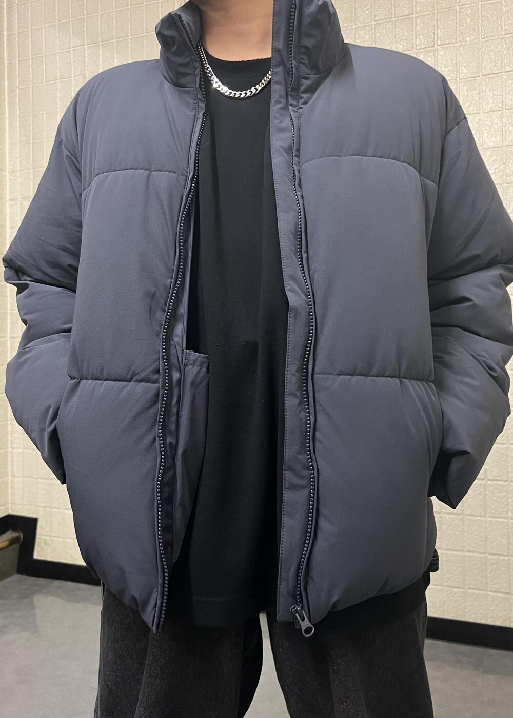 ブラック系のデニムパンツ、ブルー系のダウンジャケット/コートを着用したメンズの秋コーディネートの6枚目の写真