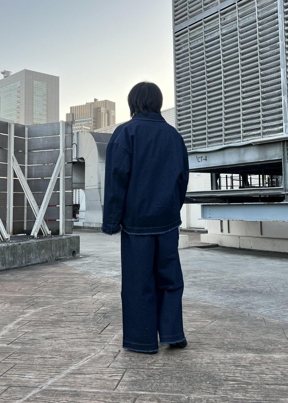 ブラック系のブーツ、ブラック系のスウェット、ブルー系のブルゾンを着用したメンズの春コーディネートの3枚目の写真