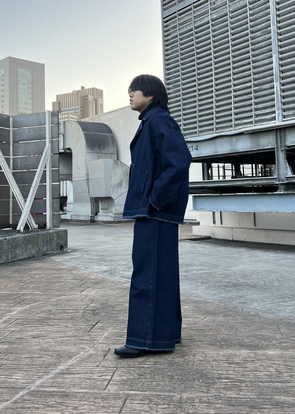 ブラック系のブーツ、ブラック系のスウェット、ブルー系のブルゾンを着用したメンズの春コーディネートの2枚目の写真