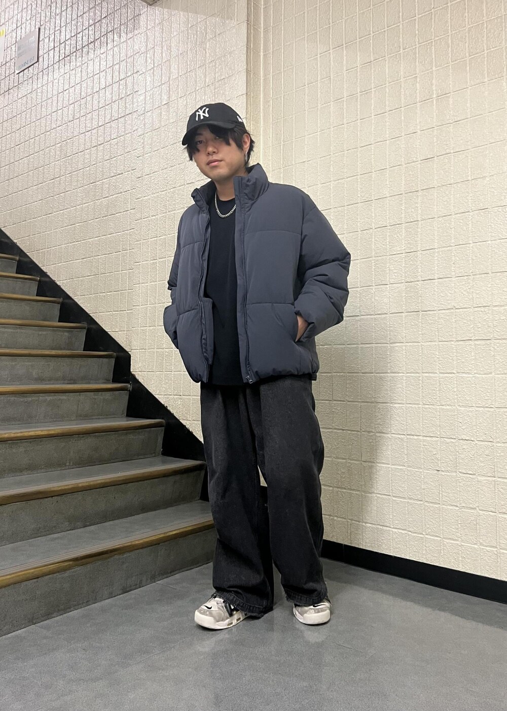 ブラック系のデニムパンツ、ブルー系のダウンジャケット/コートを着用したメンズの秋コーディネートの2枚目の写真