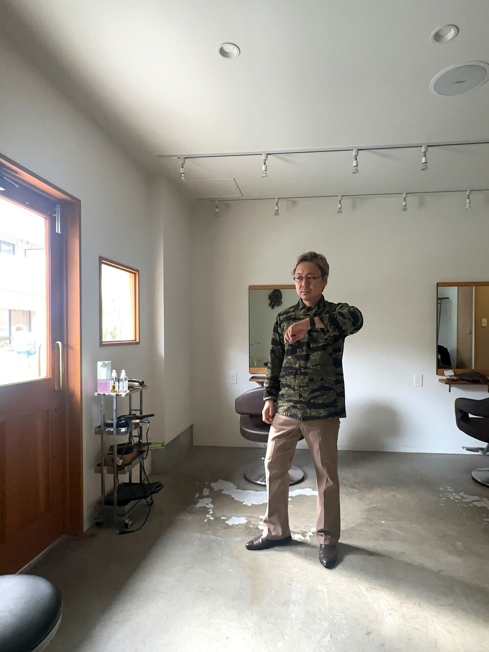 ベージュ系のスラックス、グリーン系のシャツ/ブラウスを着用したメンズの秋コーディネートの2枚目の写真