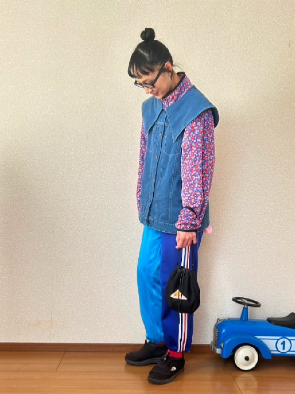 ブラック系のその他シューズ、ブルー系のベスト、パープル系のその他アウターを着用したレディースの秋コーディネートの2枚目の写真