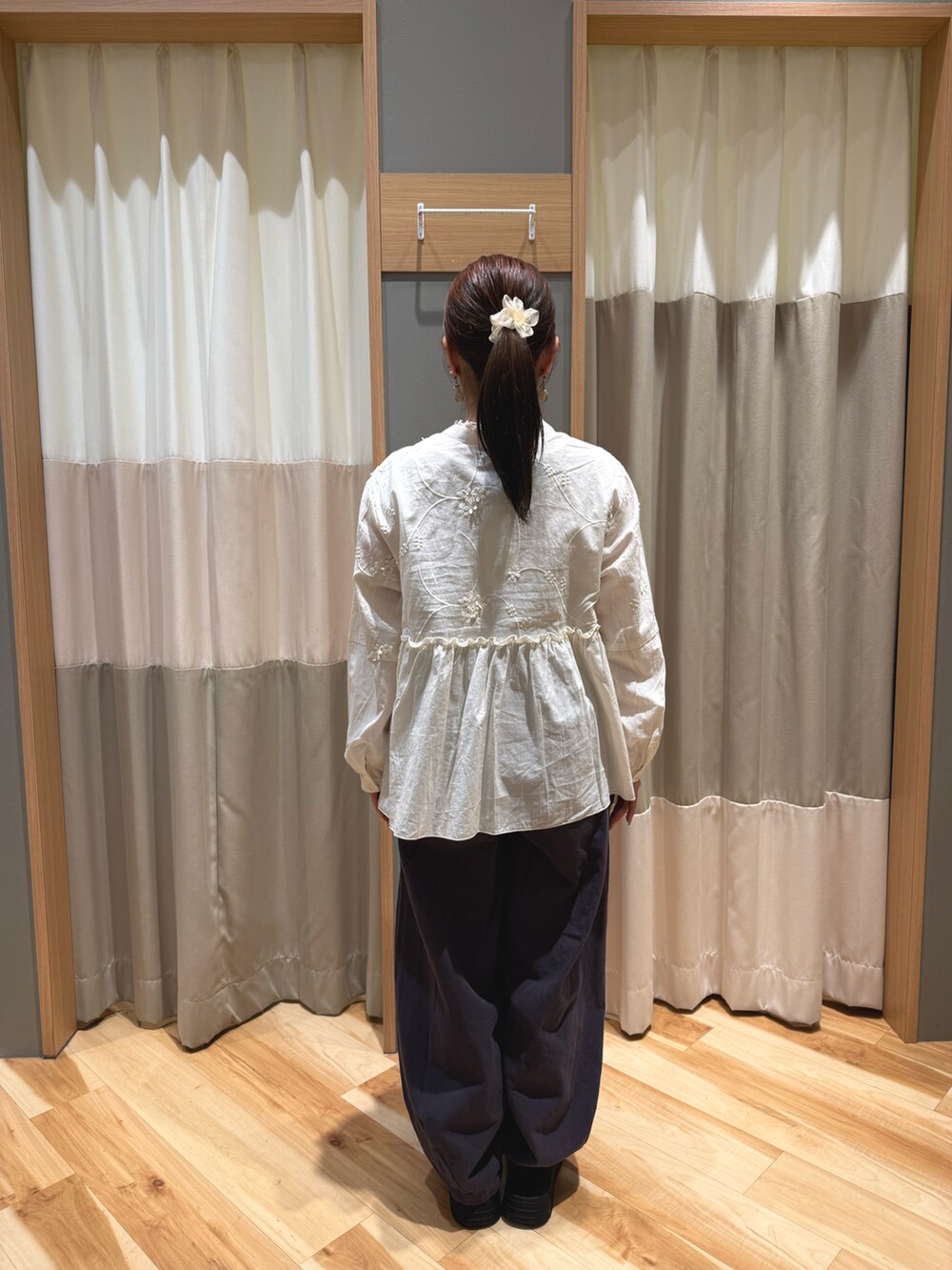 ブラック系のスニーカー、ホワイト系のハンドバッグ、ホワイト系のシャツ/ブラウスを着用したレディースの春コーディネートの3枚目の写真