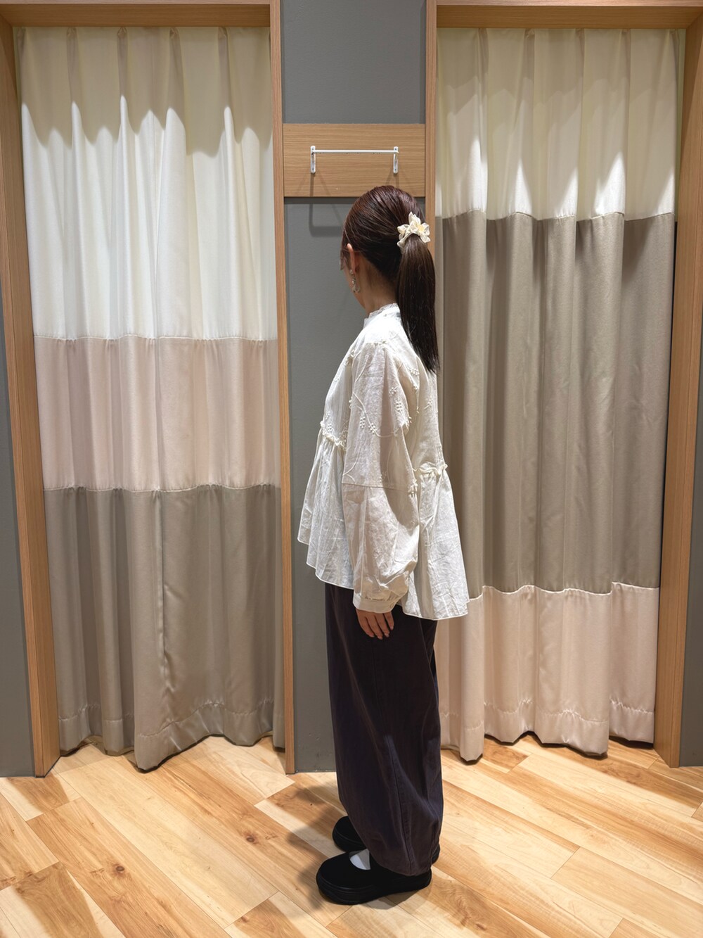 ブラック系のスニーカー、ホワイト系のハンドバッグ、ホワイト系のシャツ/ブラウスを着用したレディースの春コーディネートの4枚目の写真