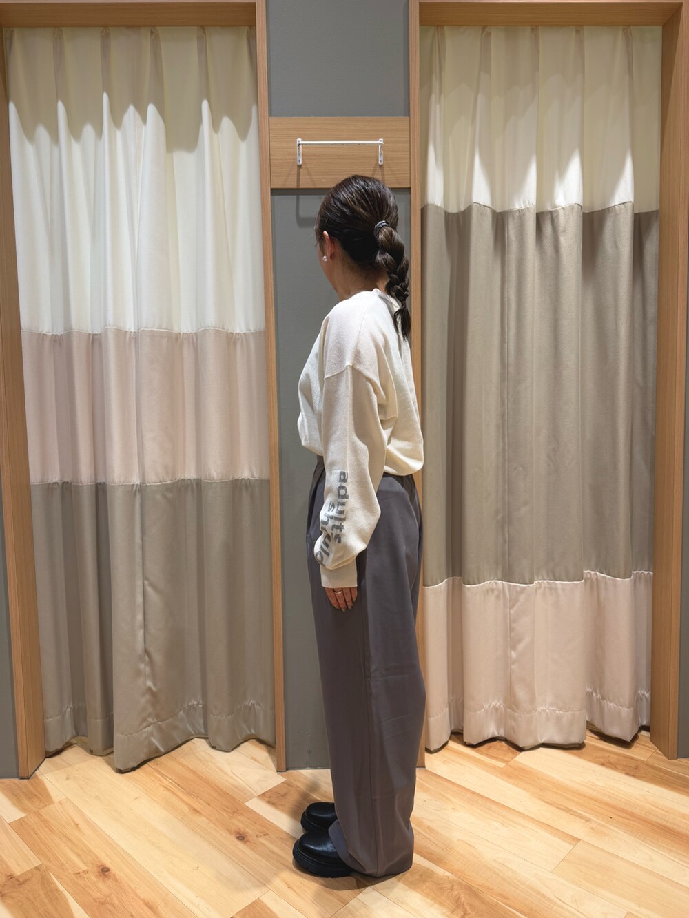 グレー系のその他パンツ、ブラック系のブーツ、ホワイト系のニット/セーターを着用したレディースの冬コーディネートの4枚目の写真