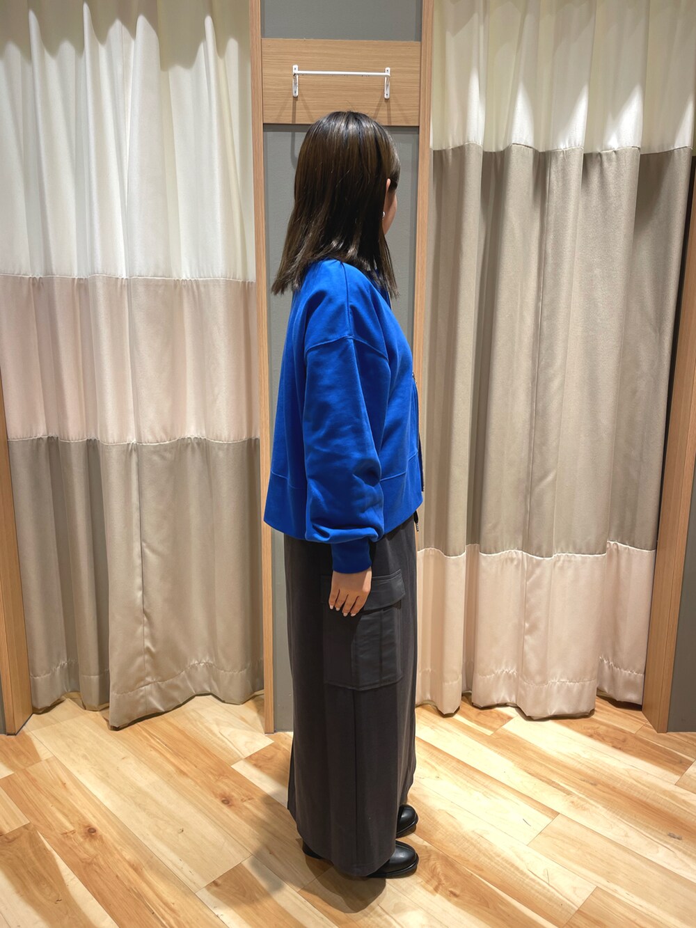 ブラック系のドレスシューズ、グレー系のスカート、ブラック系のハンドバッグを着用したレディースの秋コーディネートの2枚目の写真