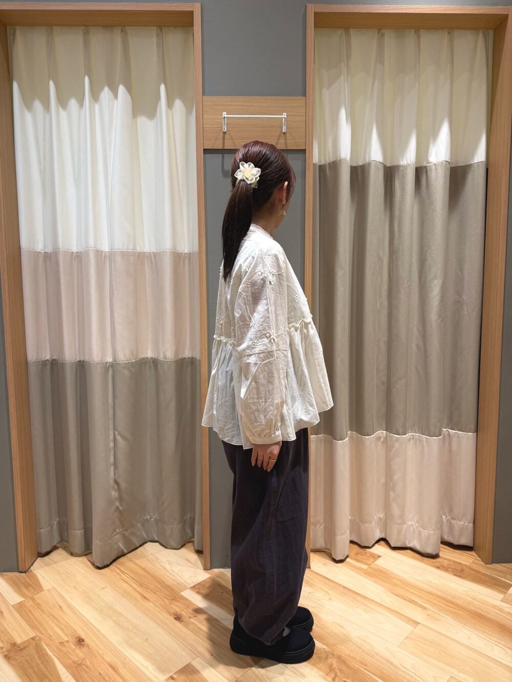 ブラック系のスニーカー、ホワイト系のハンドバッグ、ホワイト系のシャツ/ブラウスを着用したレディースの春コーディネートの2枚目の写真