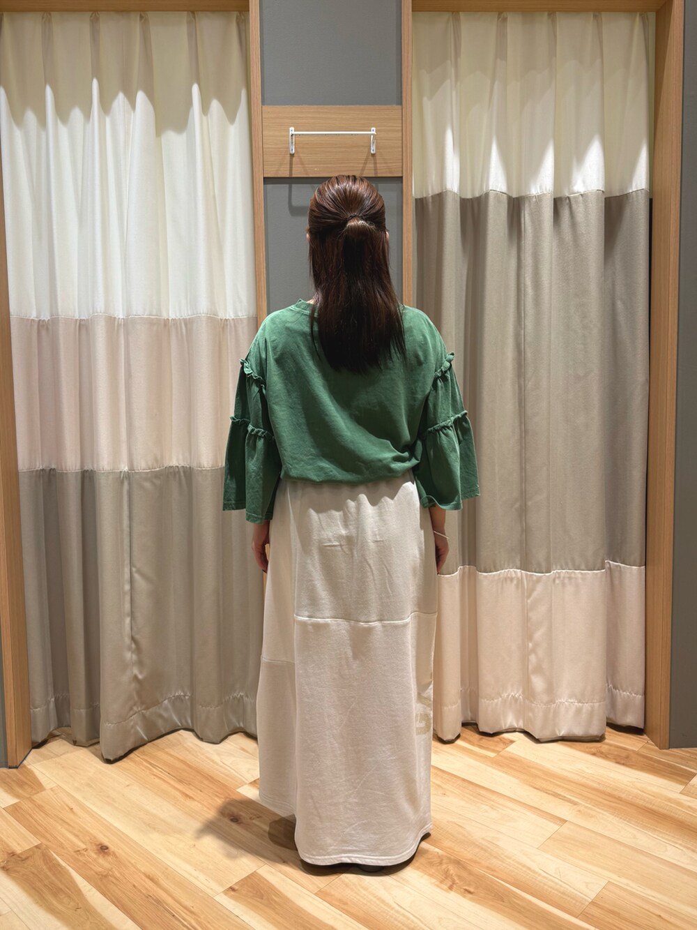 ベージュ系のスカート、グリーン系のTシャツ/カットソーを着用したレディースの春コーディネートの3枚目の写真