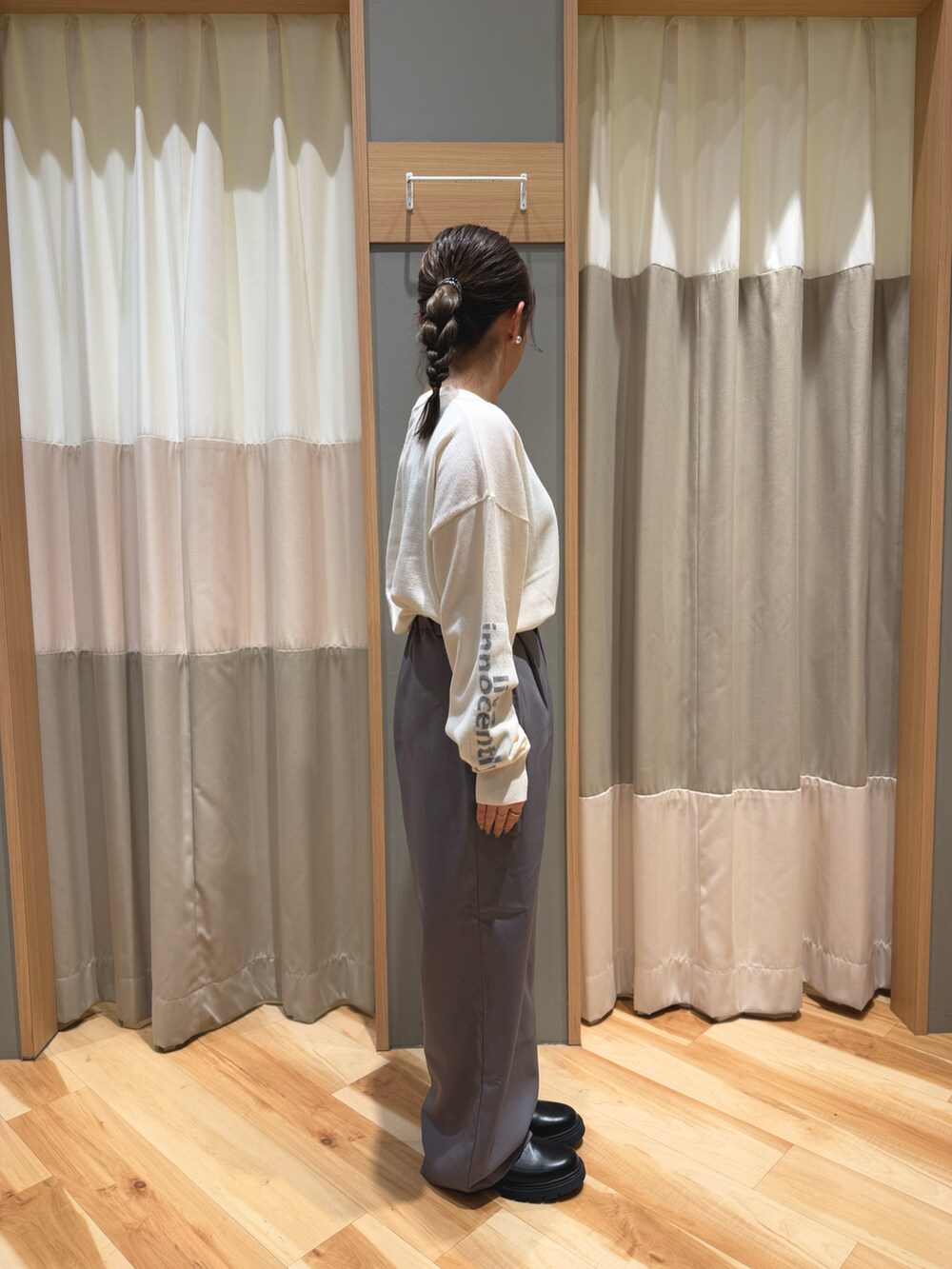 グレー系のその他パンツ、ブラック系のブーツ、ホワイト系のニット/セーターを着用したレディースの冬コーディネートの2枚目の写真