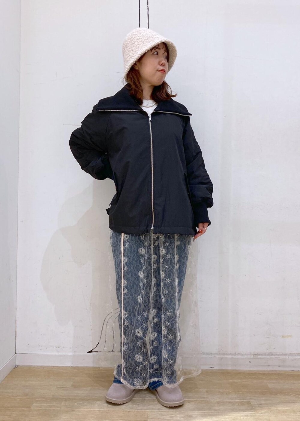 ブルー系のデニムパンツ、ホワイト系のスカート、ゴールド系のショルダーバッグを着用したレディースの秋コーディネートの5枚目の写真