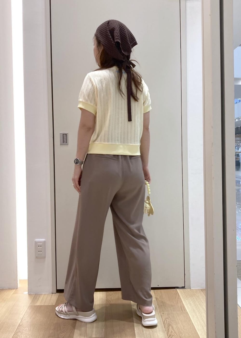 ホワイト系のサンダル、ブラウン系のその他パンツ、イエロー系のショルダーバッグを着用したレディースの夏コーディネートの2枚目の写真