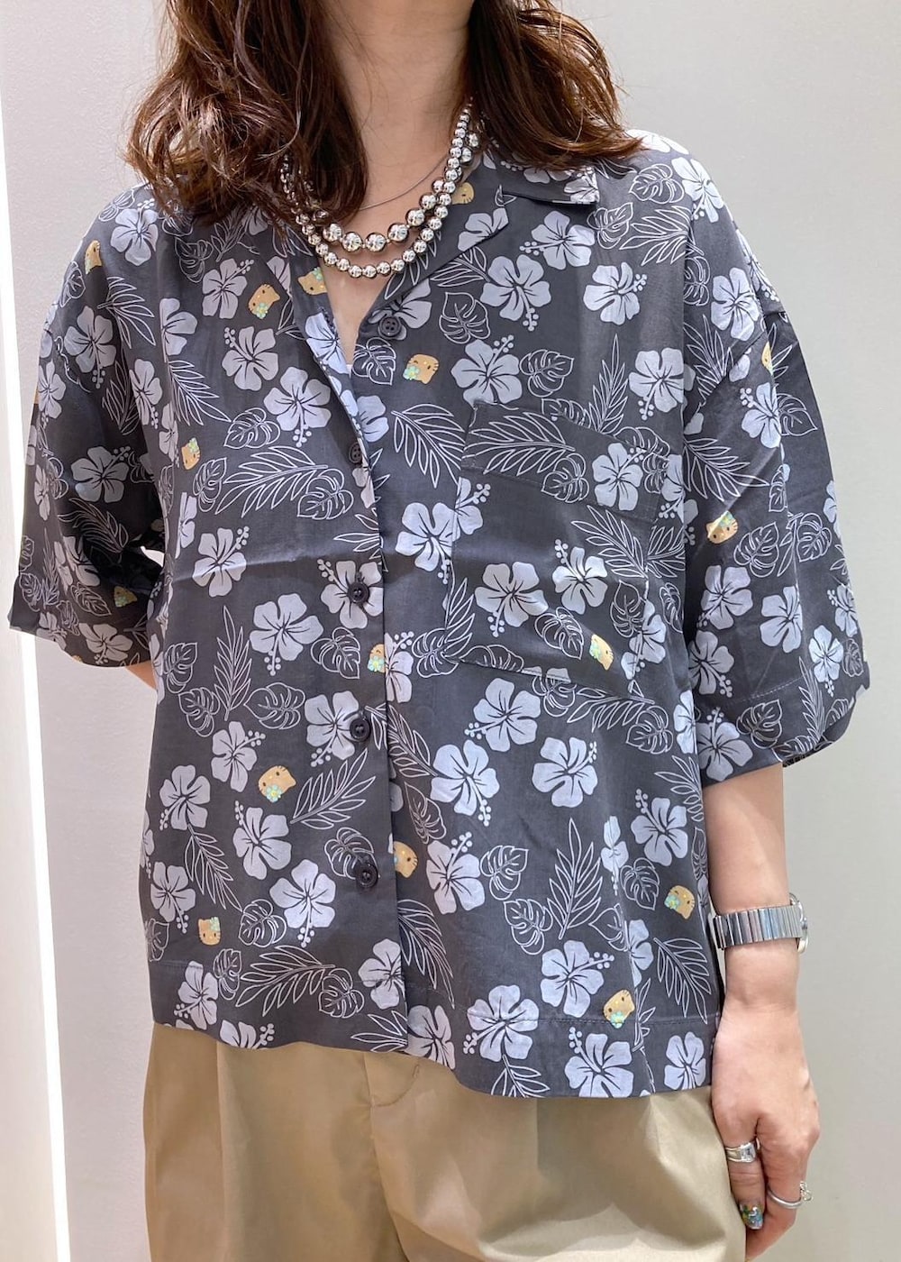 ブラック系のトートバッグ、ブラック系のサンダル、グレー系のチノパンツを着用したレディースの夏コーディネートの5枚目の写真