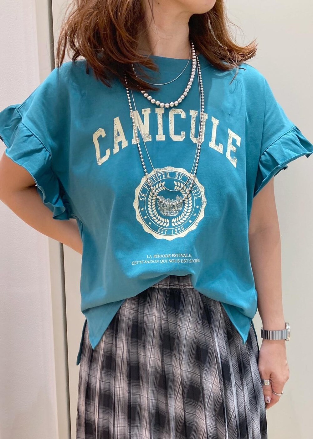 ブラック系のハンドバッグ、ブラック系のバレエシューズ、グリーン系のTシャツ/カットソーを着用したレディースの夏コーディネートの4枚目の写真