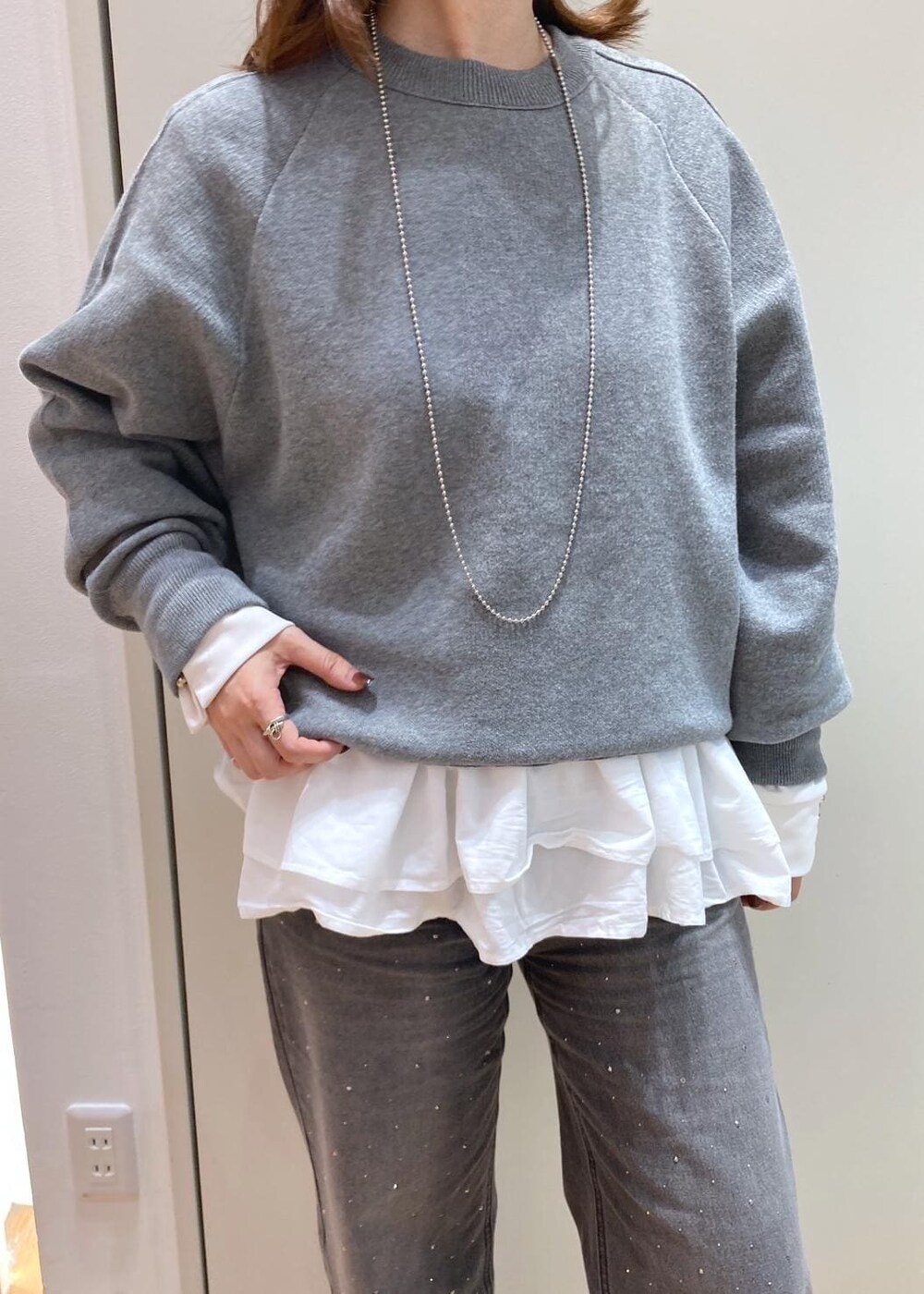 グレー系のブルゾン、グレー系のニット/セーター、ホワイト系のTシャツ/カットソーを着用したレディースの秋コーディネートの5枚目の写真