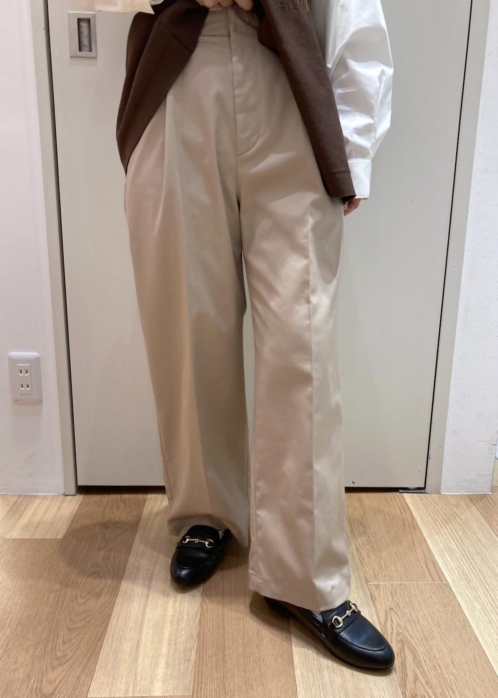 ブラック系のローファー、ブラック系のボストンバッグ、ベージュ系のチノパンツを着用したレディースの冬コーディネートの5枚目の写真