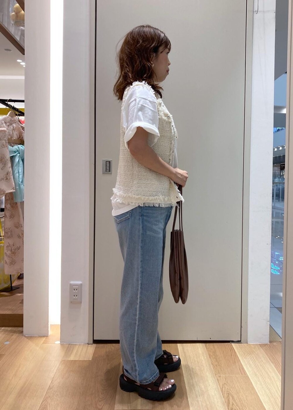 ホワイト系のカーディガン/ボレロ、ブラウン系のサンダル、ホワイト系のTシャツ/カットソーを着用したレディースの夏コーディネートの2枚目の写真