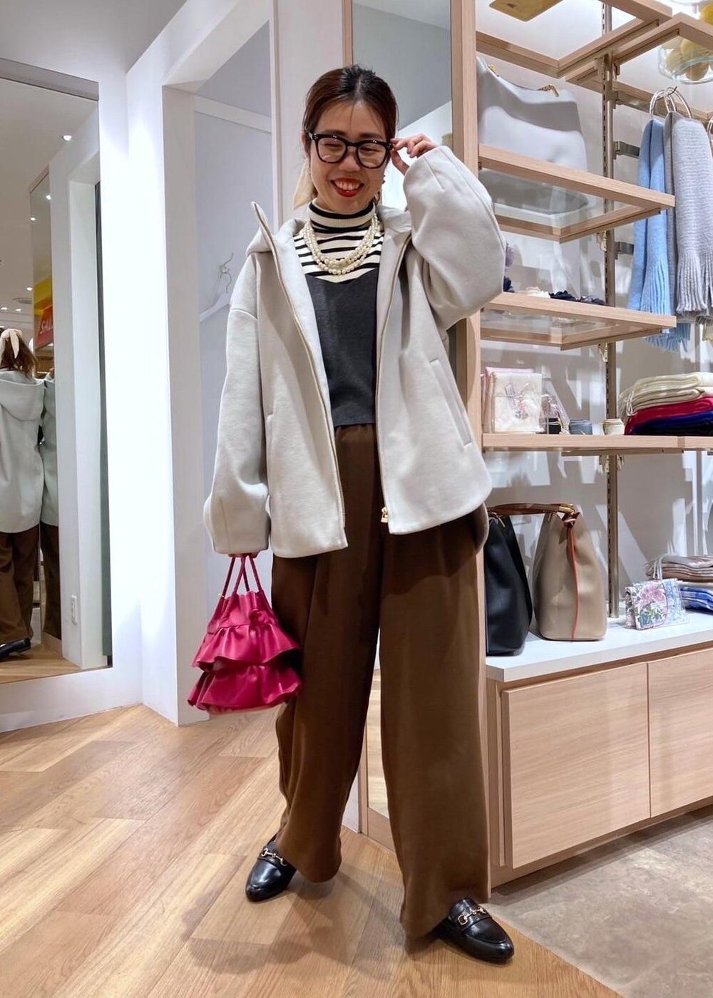 ブラック系のローファー、ベージュ系のその他アウター、ホワイト系のニット/セーターを着用したレディースの冬コーディネートの3枚目の写真