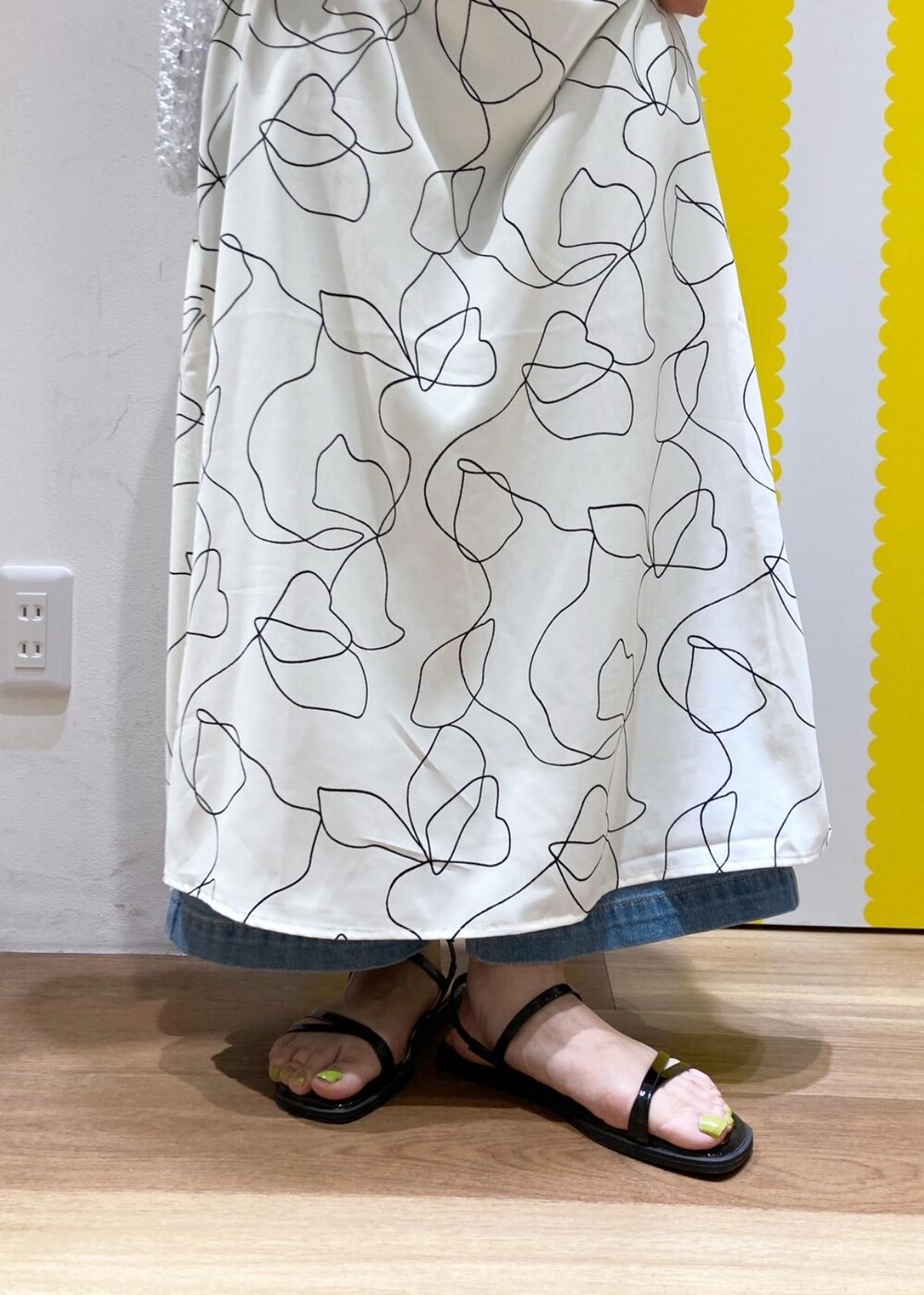 ホワイト系のワンピース、ベージュ系のTシャツ/カットソー、ブラック系のサンダルを着用したレディースの春コーディネートの5枚目の写真