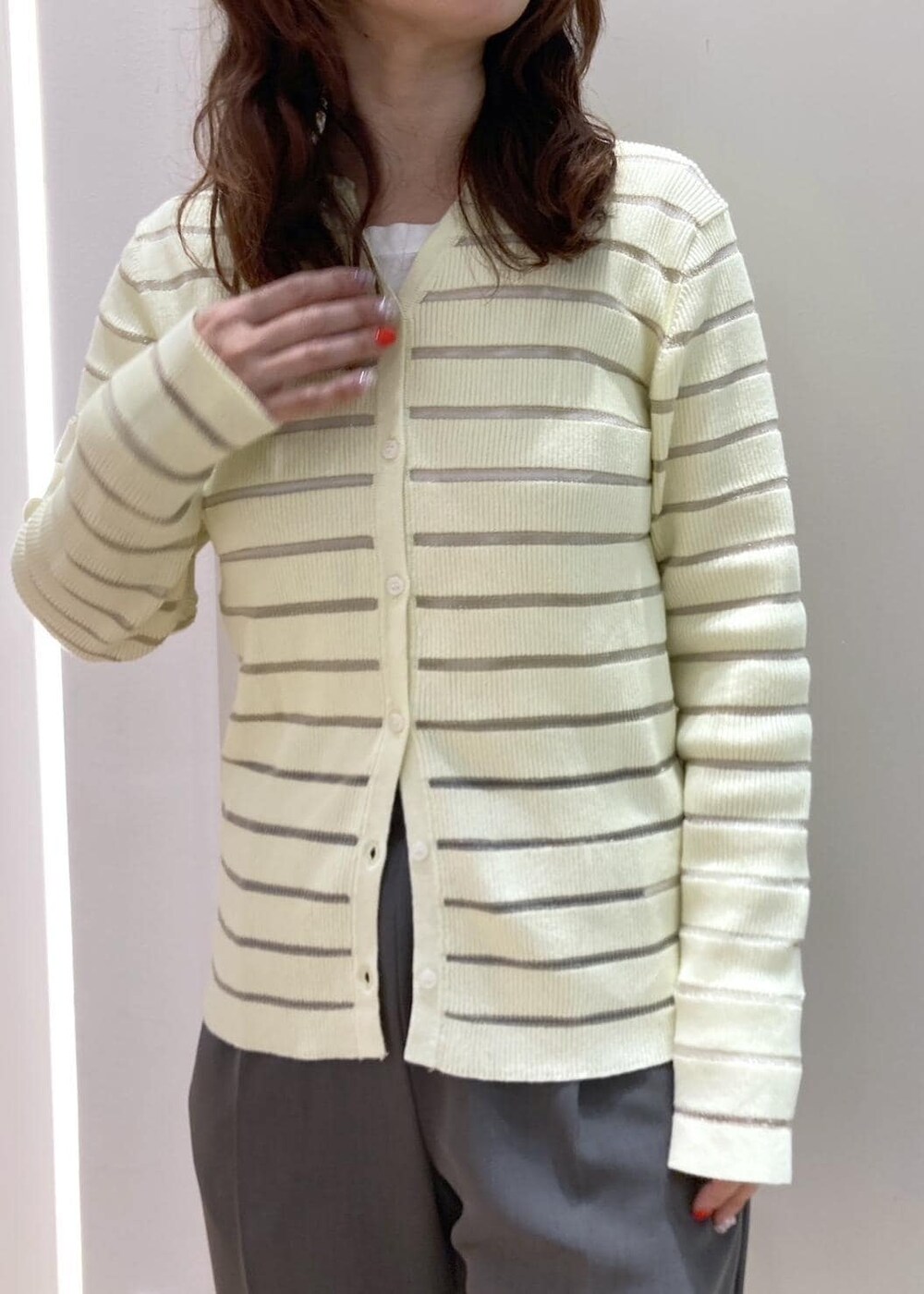 グレー系のスラックス、ベージュ系のカーディガン/ボレロ、ブラック系のバレエシューズを着用したレディースの春コーディネートの4枚目の写真