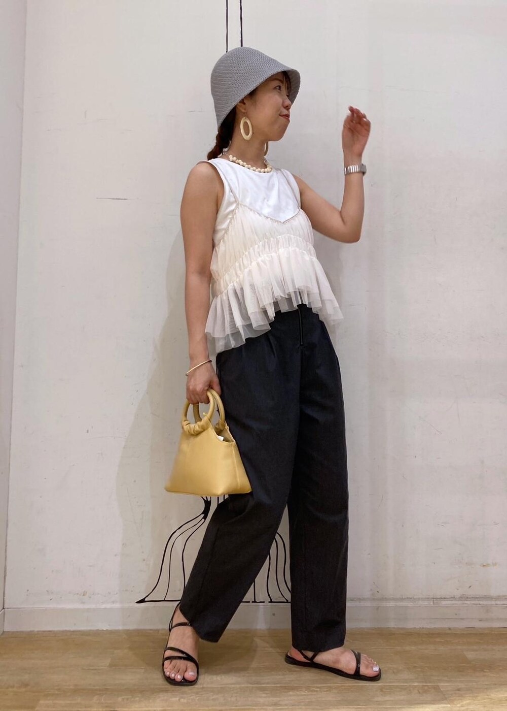 ブラック系のサンダル、ホワイト系のTシャツ/カットソー、イエロー系のショルダーバッグを着用したレディースの夏コーディネートの2枚目の写真