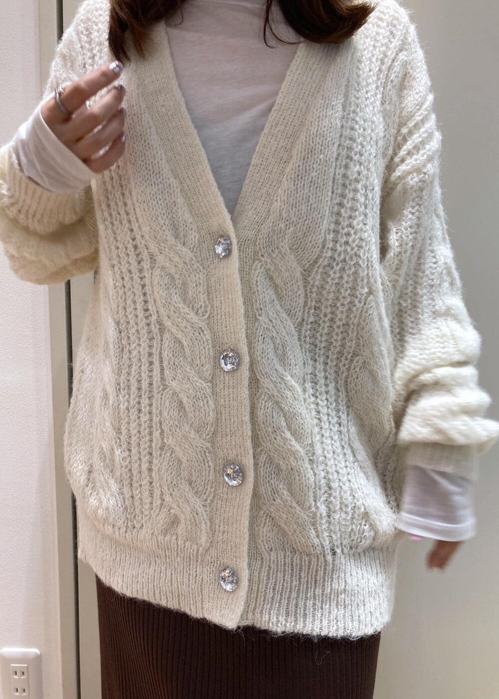 ホワイト系のTシャツ/カットソー、ブラック系のダウンジャケット/コート、ブラック系のローファーを着用したレディースの秋コーディネートの4枚目の写真