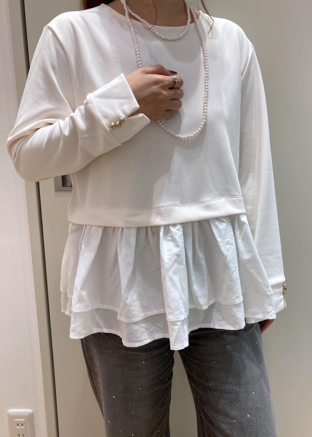 ホワイト系のダウンベスト、ホワイト系のTシャツ/カットソー、グレー系のブーツを着用したレディースの秋コーディネートの5枚目の写真