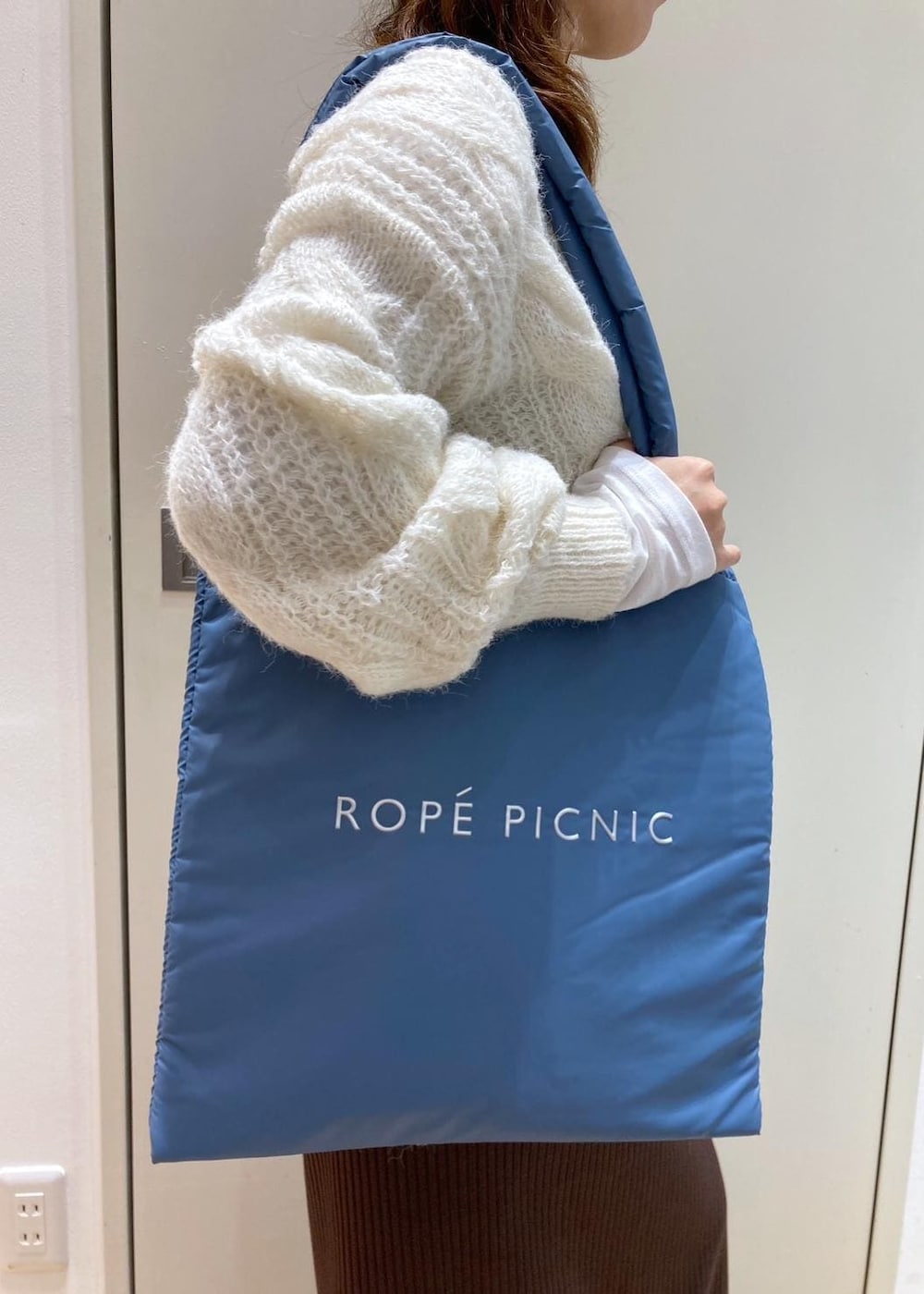 ホワイト系のTシャツ/カットソー、ブラック系のダウンジャケット/コート、ブラック系のローファーを着用したレディースの秋コーディネートの7枚目の写真