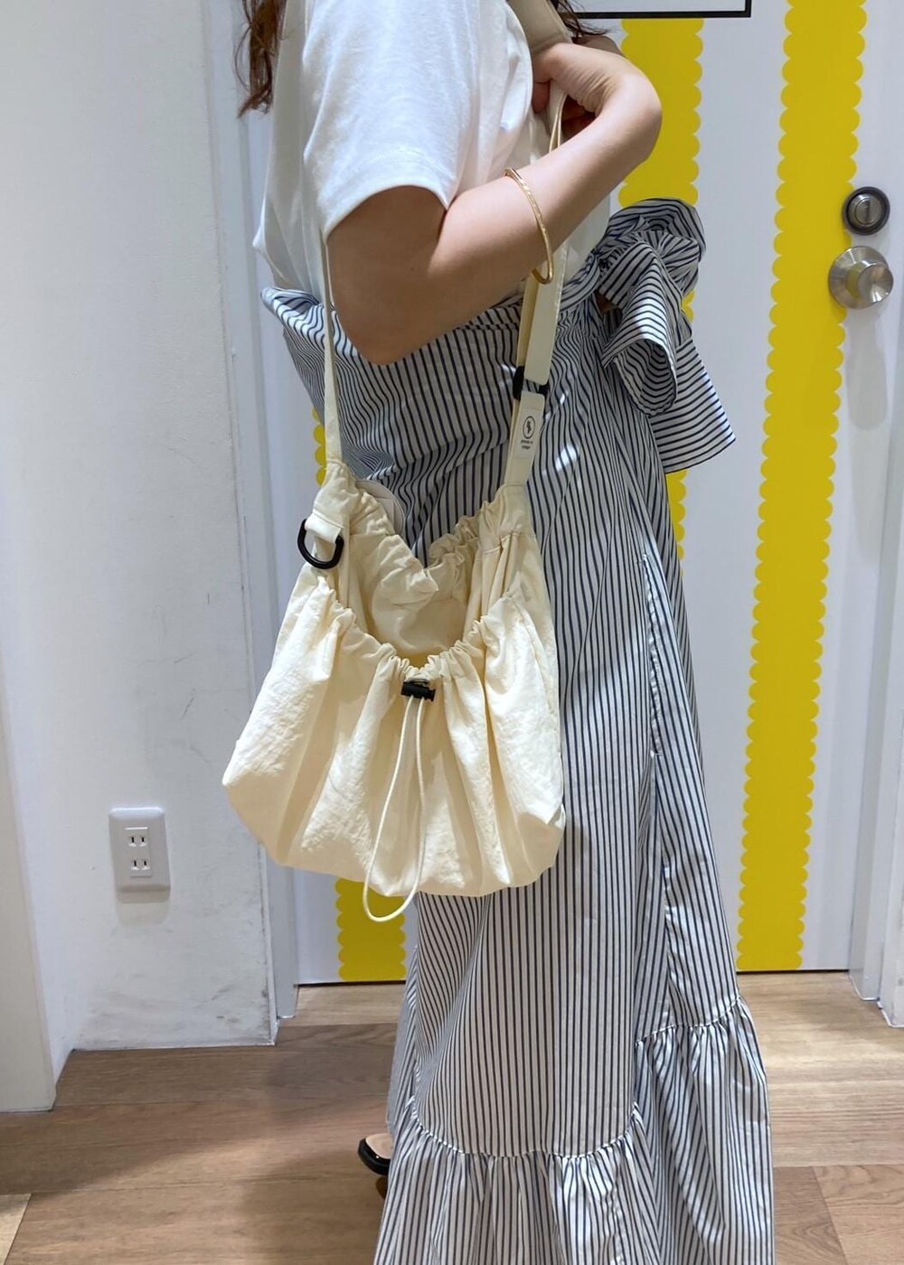 ブラック系のサンダル、ホワイト系のショルダーバッグ、ブルー系のシャツワンピースを着用したレディースの春コーディネートの8枚目の写真