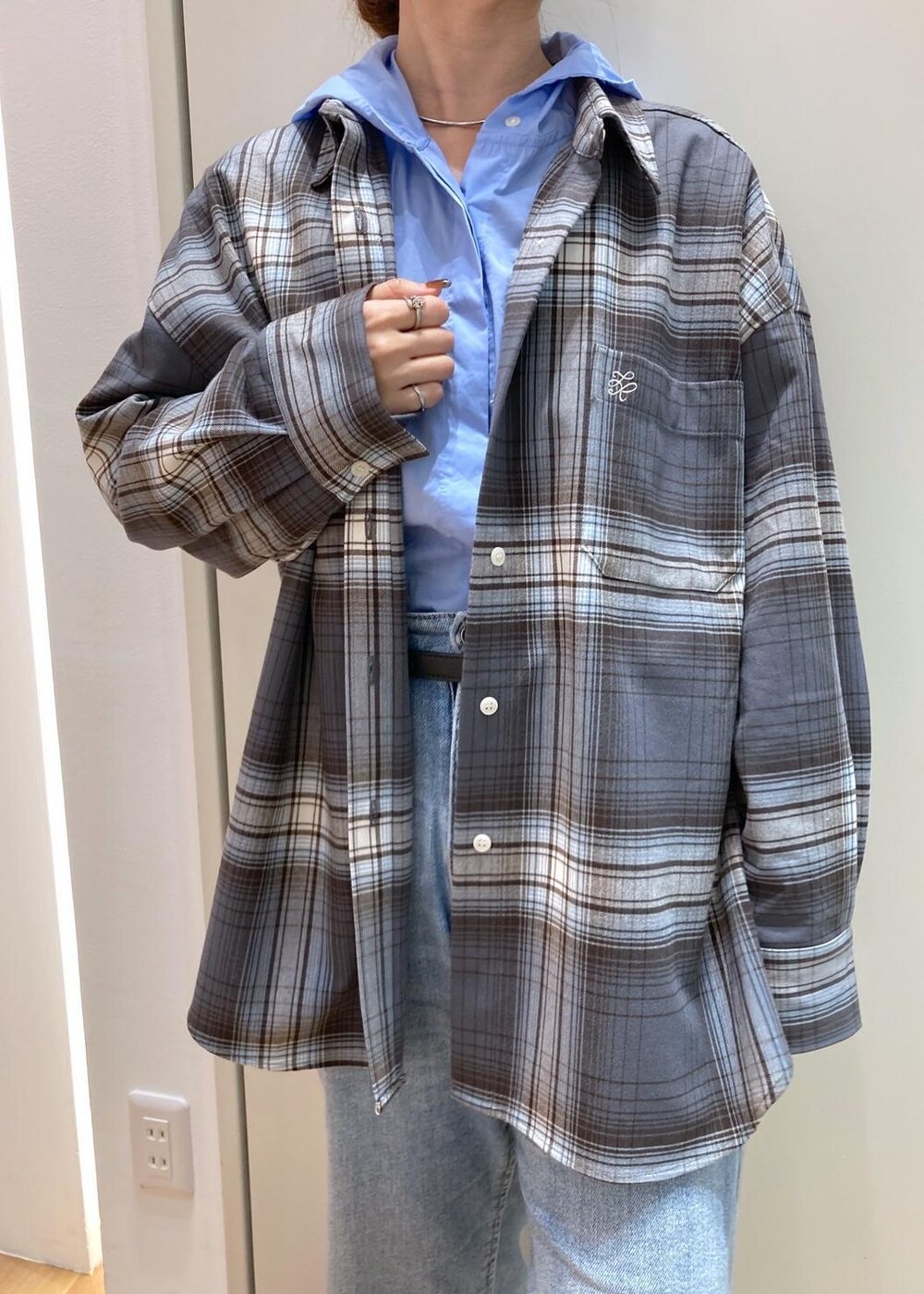 ブルー系のデニムパンツ、ブラック系のバレエシューズ、グレー系のシャツ/ブラウスを着用したレディースの秋コーディネートの5枚目の写真