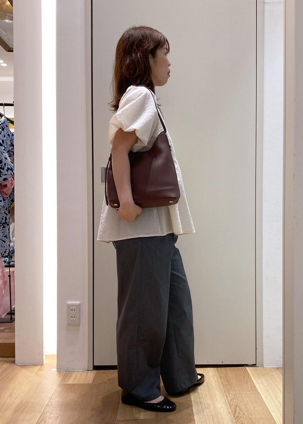 ブラック系のバレエシューズ、グレー系のチノパンツ、ホワイト系のシャツ/ブラウスを着用したレディースの夏コーディネートの3枚目の写真