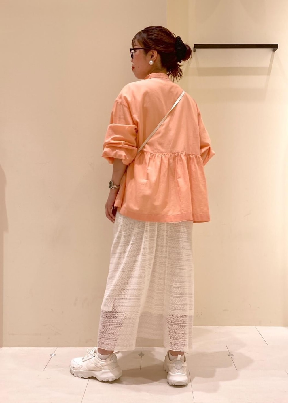 オレンジ系のシャツ/ブラウス、ベージュ系のショルダーバッグ、ホワイト系のTシャツ/カットソーを着用したレディースの春コーディネートの3枚目の写真