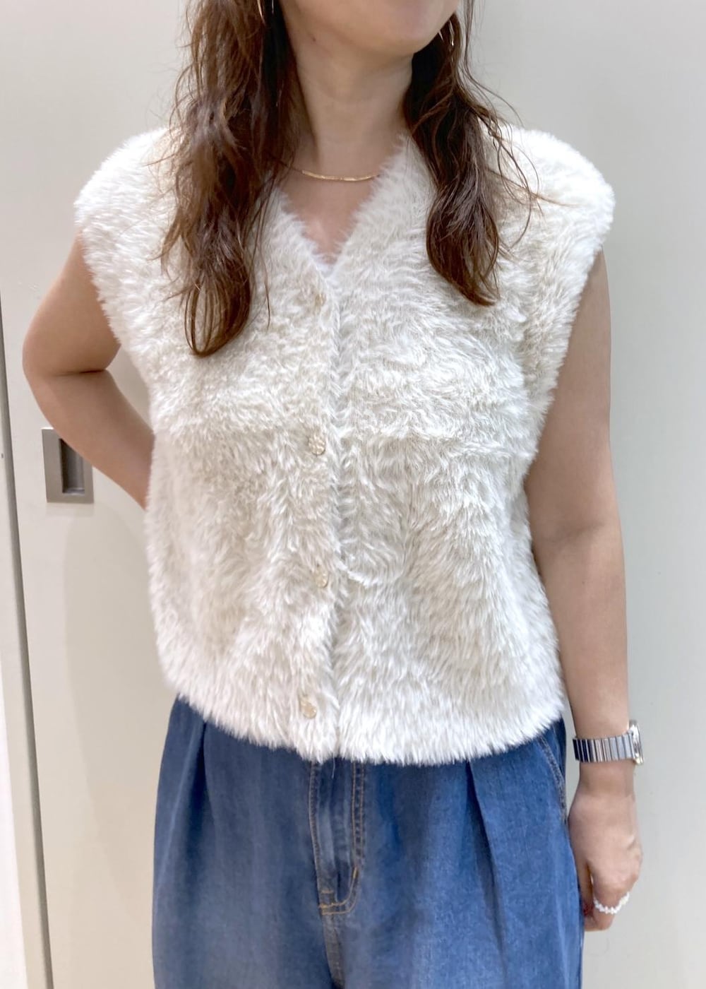 ブラウン系のパンプス、ブルー系のデニムパンツ、レッド系のトートバッグを着用したレディースの夏コーディネートの4枚目の写真