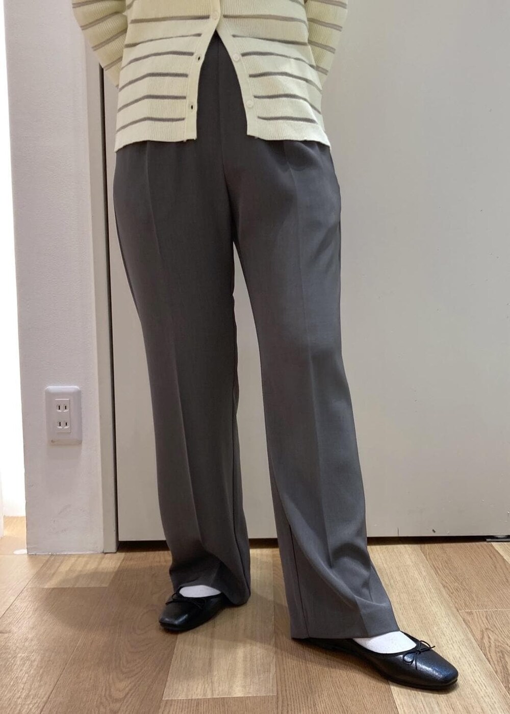 グレー系のスラックス、ベージュ系のカーディガン/ボレロ、ブラック系のバレエシューズを着用したレディースの春コーディネートの5枚目の写真