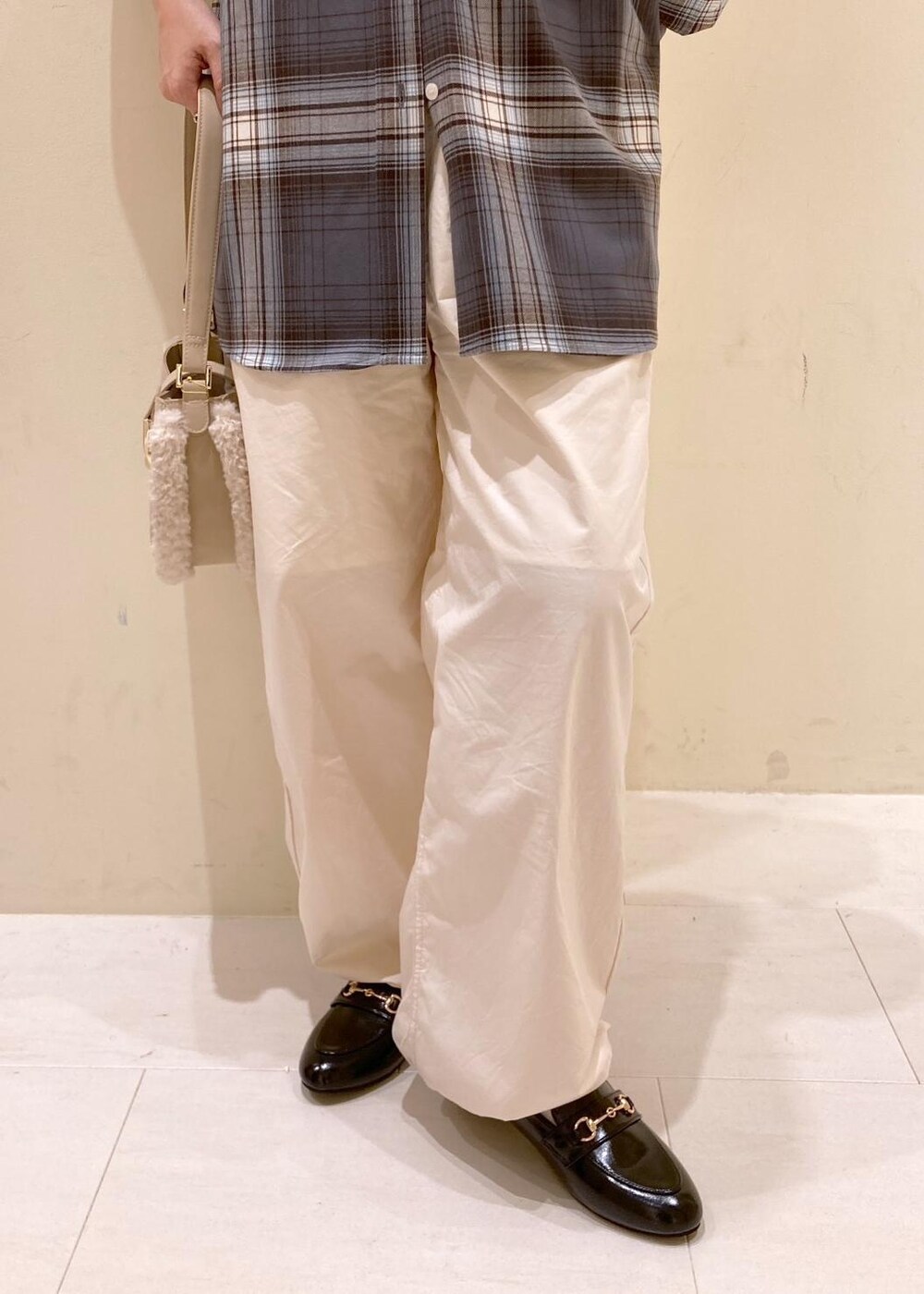 ホワイト系のその他パンツ、ブラック系のローファー、グレー系のシャツ/ブラウスを着用したレディースの秋コーディネートの6枚目の写真