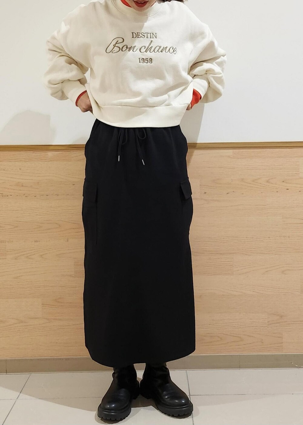 レッド系のニット/セーター、ホワイト系のダウンジャケット/コート、ブラック系のトートバッグを着用したレディースの冬コーディネートの2枚目の写真