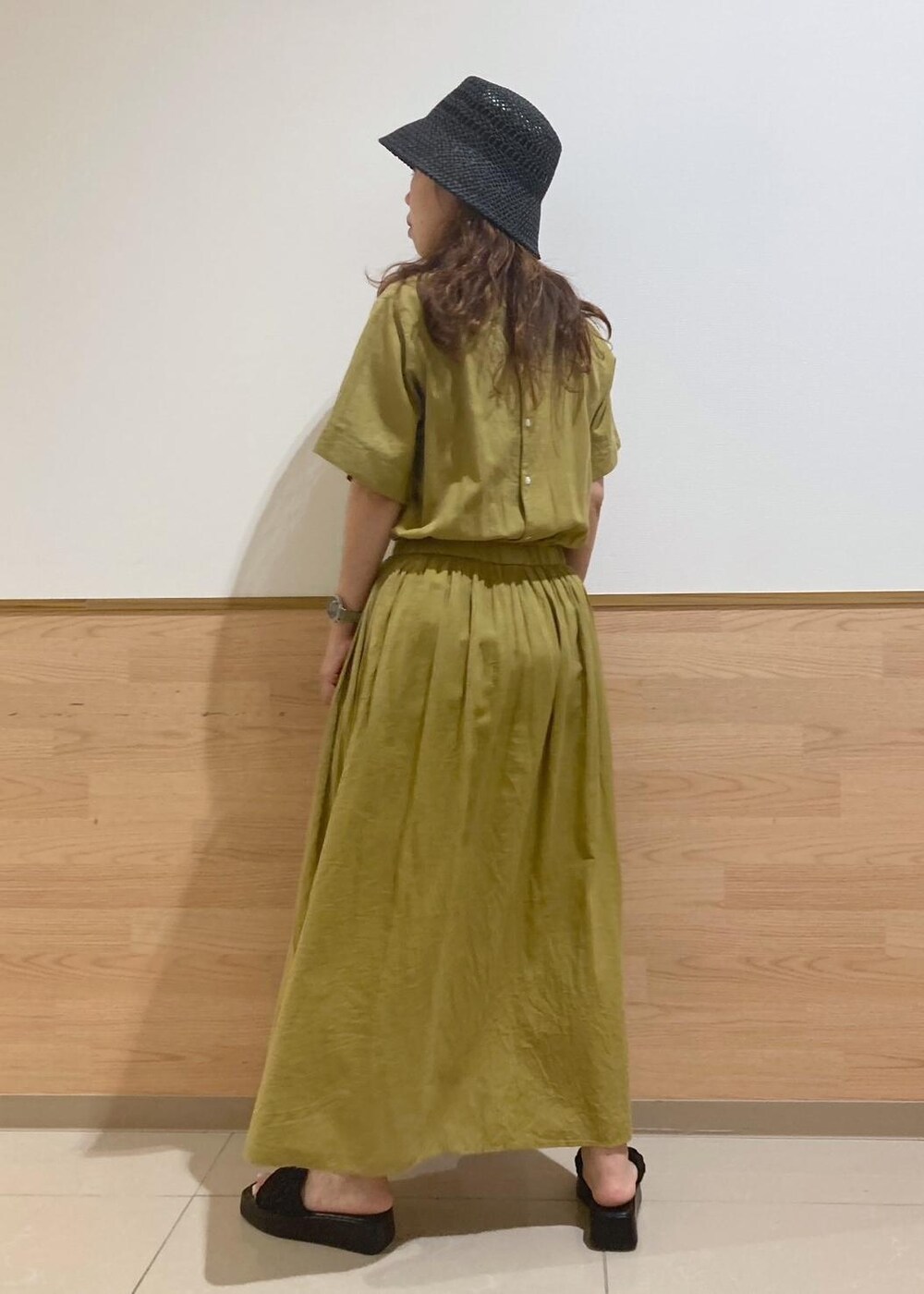 ブラック系のサンダル、ブラック系のかごバッグ、イエロー系のワンピースを着用したレディースの夏コーディネートの3枚目の写真