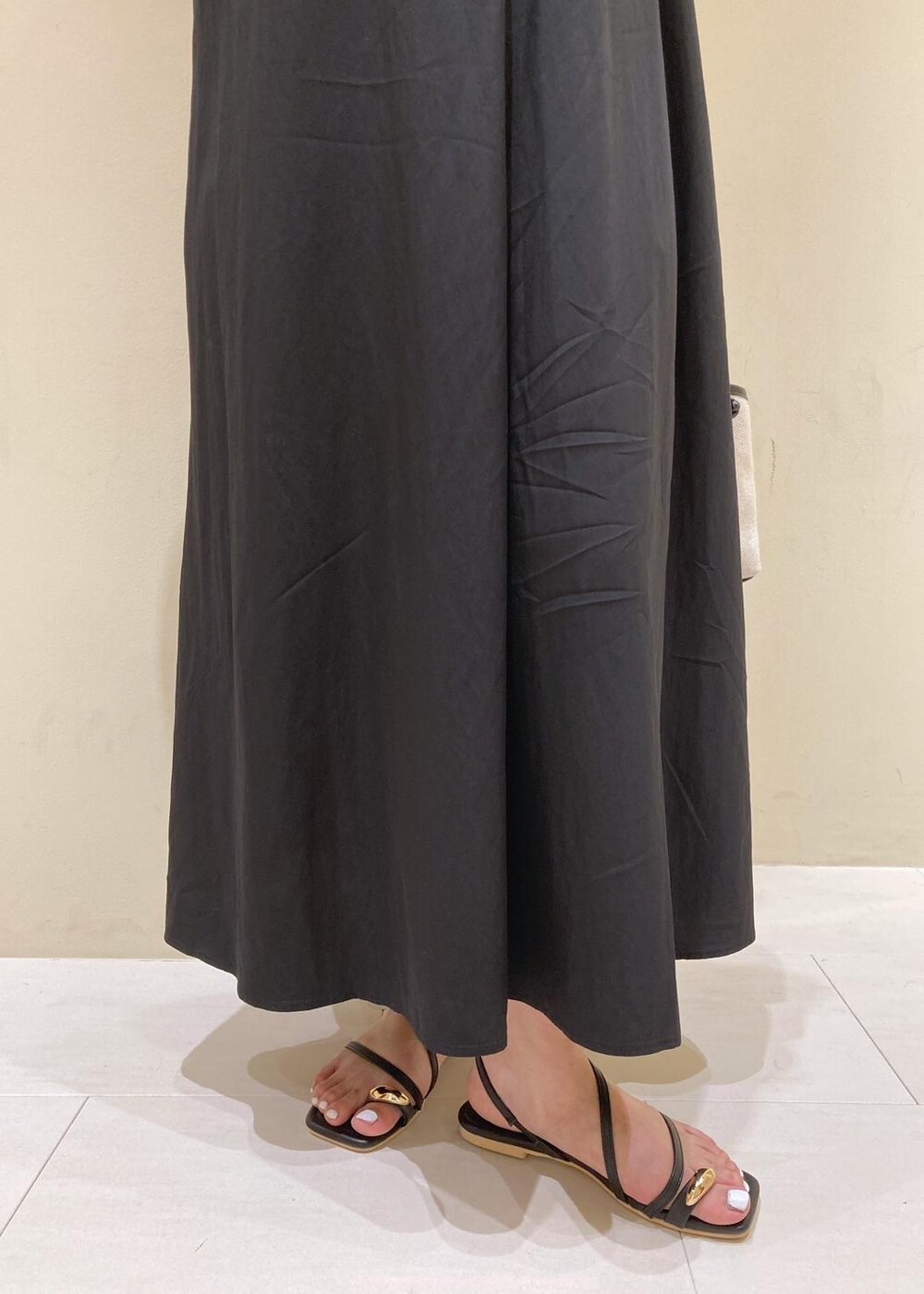 ブラック系のサンダル、ブラック系のワンピース、グレー系のカーディガン/ボレロを着用したレディースの夏コーディネートの6枚目の写真