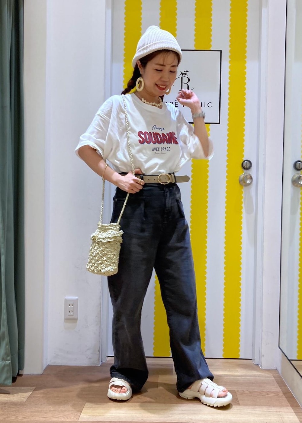 ホワイト系のサンダル、ゴールド系のショルダーバッグ、ブラック系のデニムパンツを着用したレディースの夏コーディネートの2枚目の写真