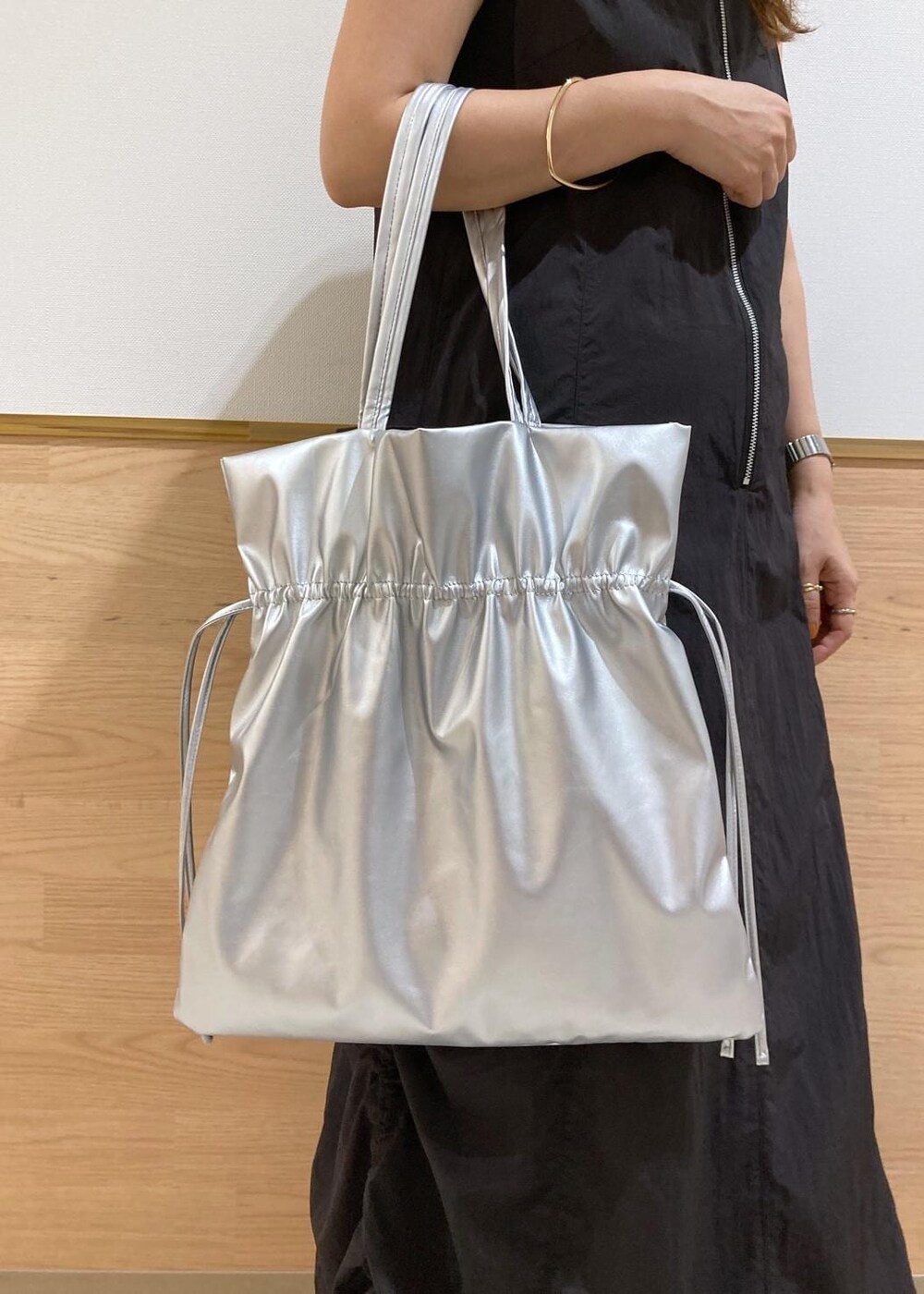 シルバー系のサンダル、ブラック系のワンピース、シルバー系のトートバッグを着用したレディースの夏コーディネートの9枚目の写真