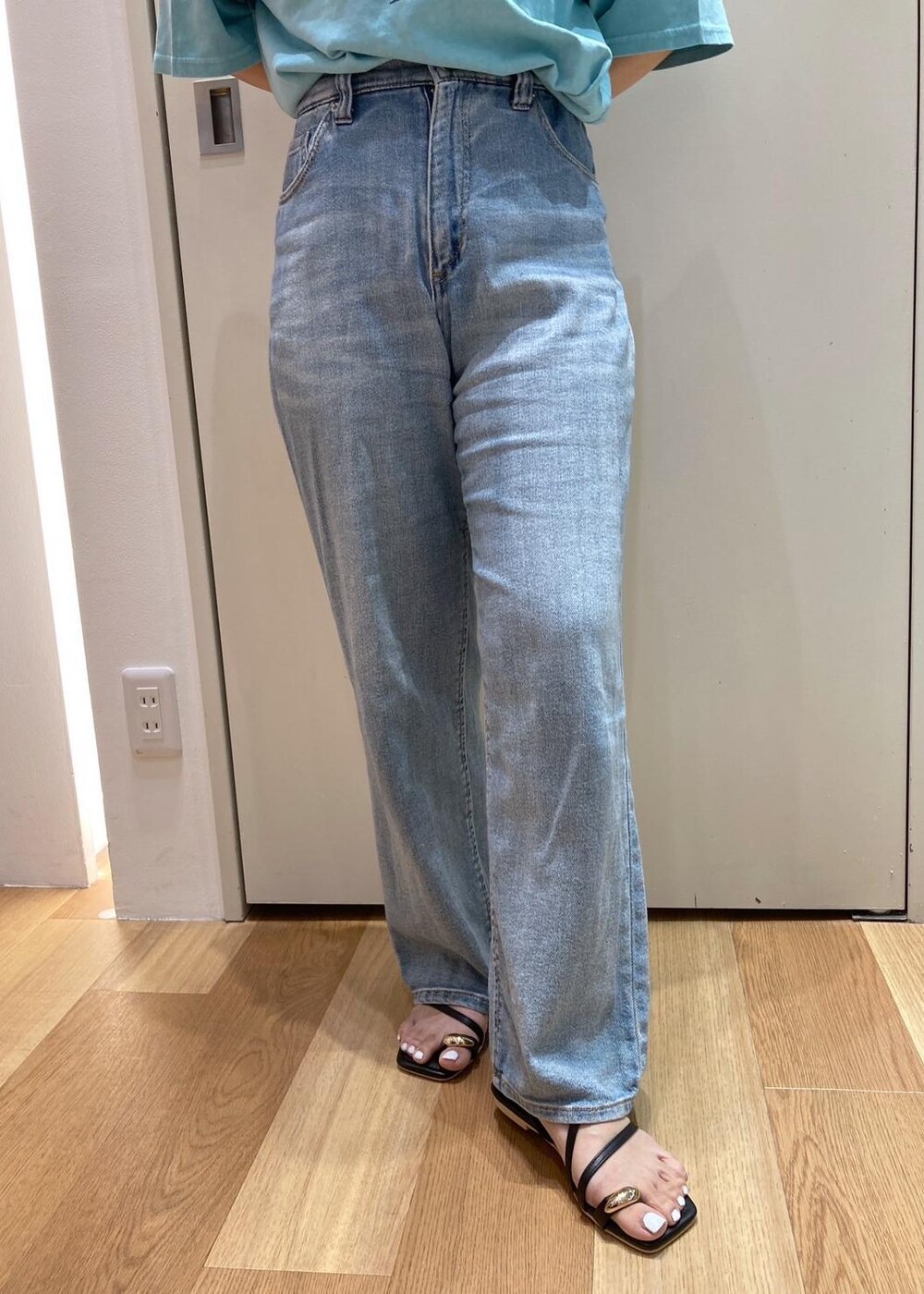 ブラック系のサンダル、ブラック系のハンドバッグ、ブルー系のTシャツ/カットソーを着用したレディースの夏コーディネートの6枚目の写真